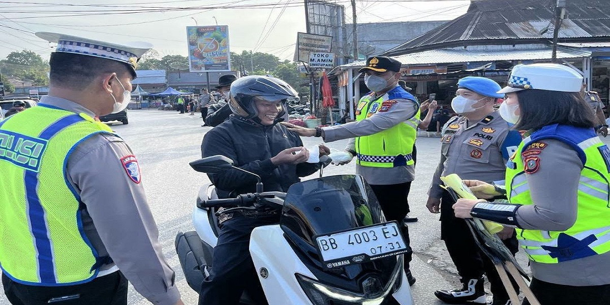 Kapolres Toba Turun ke Jalan Atur Lalu Lintas Sekaligus Bagikan Masker ke Warga